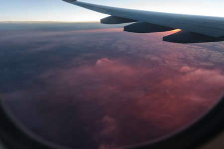 Wing of a airplane at sunrise at an altitude of 11 km.の写真素材