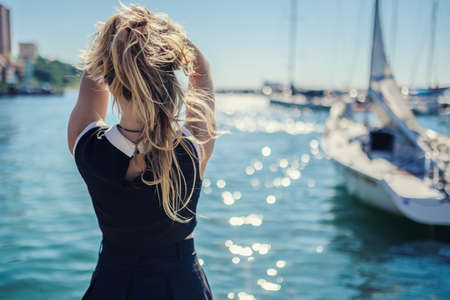 Woman in dress enjoys sea on the pier.の写真素材