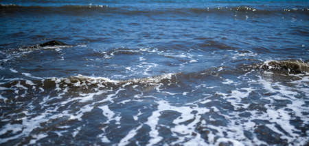 Waves at the seashore. Selective focus with shallow depth of field.の写真素材
