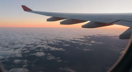 Wing of a airplane at sunrise at an altitude of 11 km.の写真素材