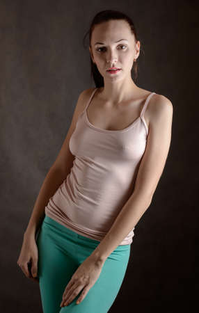 Portrait of beautiful sensual woman in T-shirt on a dark background.の写真素材