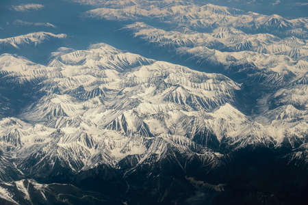 View from airplane on Earth surface - snow-capped mountains.の写真素材
