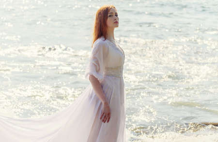Young woman over blue sea background.の写真素材