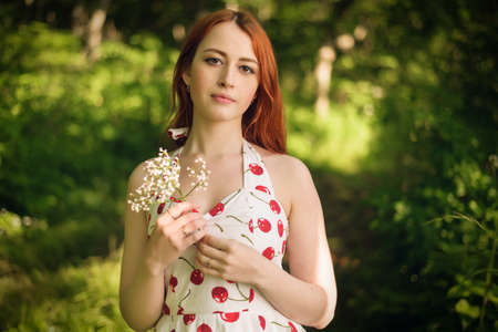 Outdoors portrait of beautiful young woman in the park. Selective focus.の写真素材
