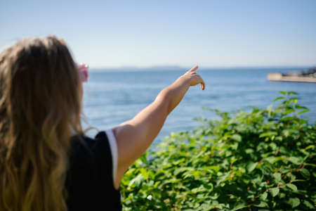 Summertime portrait of beautiful woman - she reaching to towards sky.の写真素材