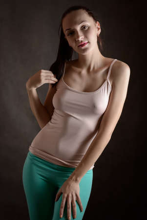 Portrait of beautiful sensual woman in T-shirt on a dark background.の写真素材