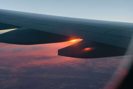 Wing of a airplane at sunrise at an altitude of 11 km.の写真素材