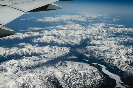 View from airplane on Earth surface - snow-capped mountains.