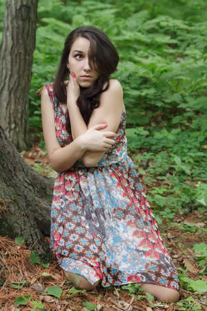 Scared young woman a forest at night.の写真素材