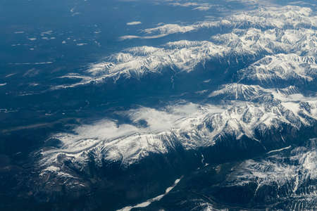 View from airplane on Earth surface - snow-capped mountains.の写真素材