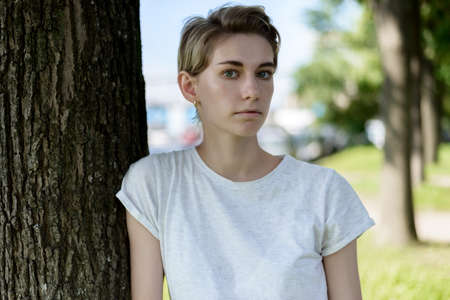Outdoors portrait of beautiful young woman with green eyes.の写真素材