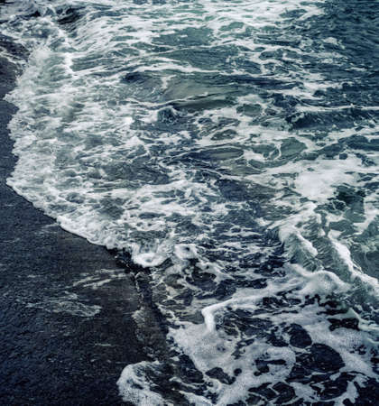 Waves at the seashore or pier. Selective focus with shallow depth of field.の写真素材