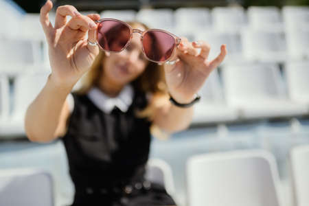 Woman in dress enjoys sun in summertime. Selective focus on sunglasess.の写真素材