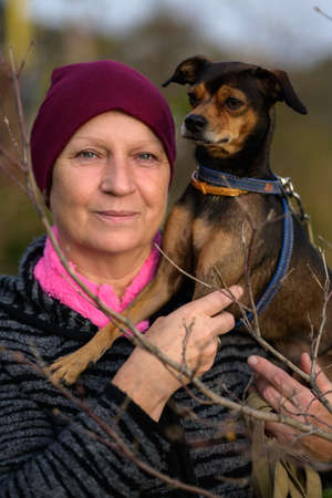 Aged woman with her dog. Selective focus.の写真素材