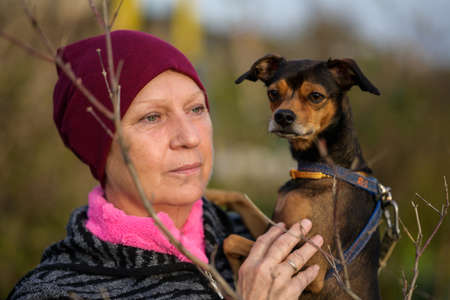 Aged woman hugging dog background.の写真素材