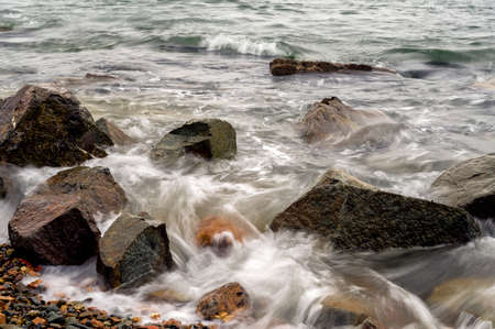 Waves at the seashore or pier captured with a slow shutter speed. Natural abstract motion background.の写真素材