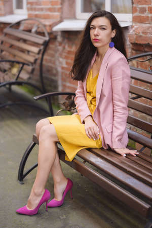 Autumn portrait of beautiful woman in yellow dress and pink blazer.の写真素材