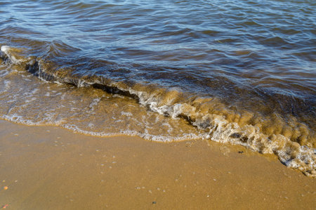Waves at the seashore at sunset. Selective focus with shallow depth of field.の写真素材