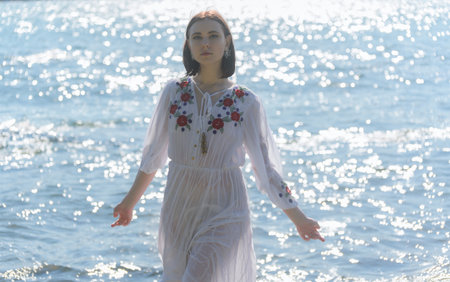 Young woman in white dress enjoys sea.の写真素材