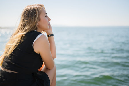 Woman in dress enjoys sea on the pier.の写真素材