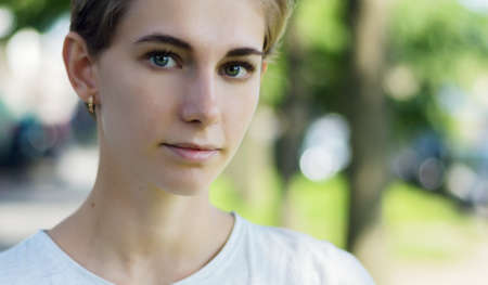 Outdoors portrait of beautiful young woman with green eyes.の写真素材