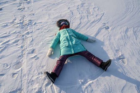 Liitle girl does a snow angel.の写真素材