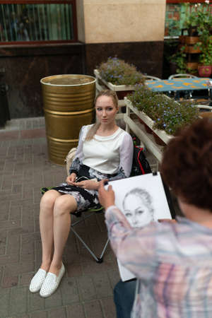 Artist draws a portrait of a young woman.の写真素材