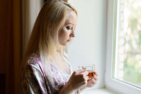 Girl with a cup of tea. Selective focus.の写真素材