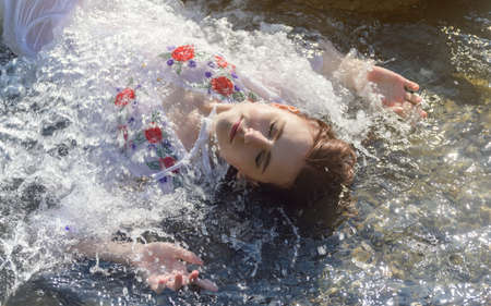 Young woman in white dress enjoys sea.の写真素材