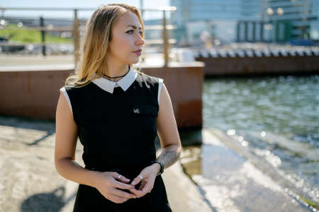Woman in dress enjoys sea on the pier.