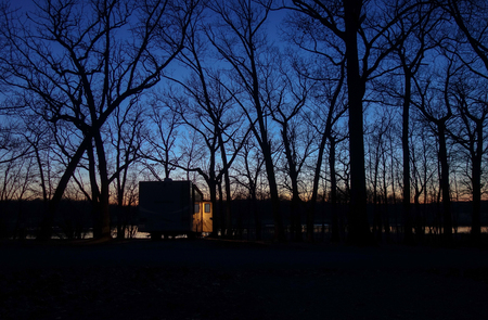 Peaceful quiet scene of a solitary camper in the forest at dusk.の写真素材