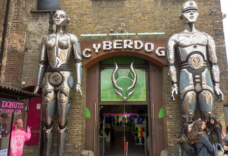 LONDON, UNITED KINGDOM â MARCH 23, 2018: People gather in front of the giant robots at the entrance of Cyberdog, a trance music and cyber clothing store in Camden Market.のeditorial素材