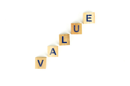 The word value is spelled out vertically with wooden blocks, each block containing one letter of the word. The blocks are arranged diagonally.の写真素材