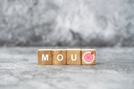 Wooden blocks spelling MOU with a target symbol on the last block, representing a Memorandum of Understanding and its goals.の写真素材