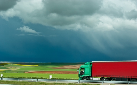 red truck is very contasty on a background of green fieldsの写真素材