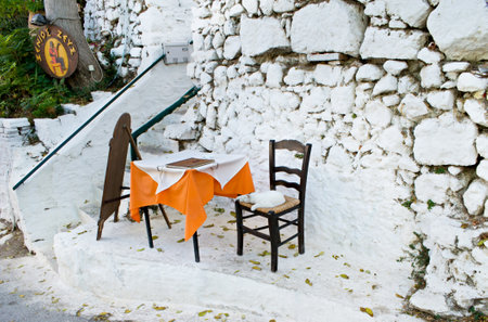 ATHENS, GREECE - OCTOBER 12, 2013: The entrance to the cafe with menu on the table and slipping white cat on the chair, on October 12 in Athens.のeditorial素材
