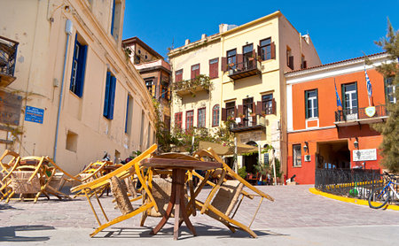 CHANIA, GREECE - OCTOBER 14, 2013: The street cafe is closed during siesta, the tiny tables stand near of the entrance to the museum of Firkas Fortress, on October 14 in Chania.のeditorial素材