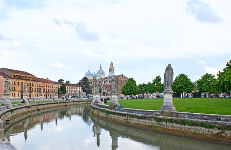 PADUA, ITALY - APRIL 23, 2012: The Prato della Valle is the major city square with the circle canals, surrounded by the sculptures with the Abbey and Basilica of St Giustina on the background, on April 23 in Padua.のeditorial素材
