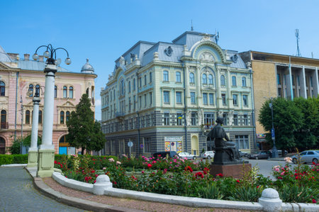 CHERNIVTSI, UKRAINE - JUNE 20, 2014: The  monument to Olha Kobylanska, famous ukrainian writer with the Regional Palace of Culture and the Jewish people's house on the background, on June 20, 2014.のeditorial素材