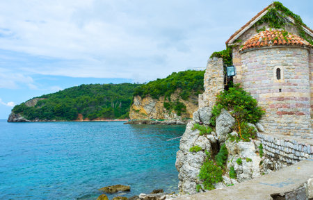 The cliffs on the coastline with the medieval church, located in the town-citadel of Budva, Montenegro.のeditorial素材
