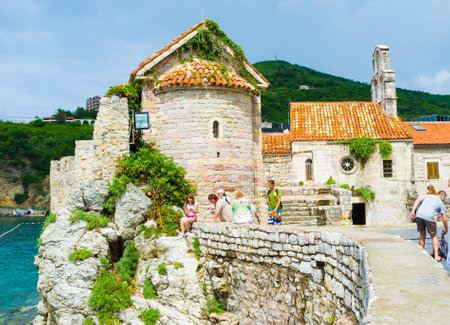 BUDVA, MONTENEGRO - JULY 12, 2014: The Saint Sava Church and Santa Maria in Punta located next to the fortress wall and boasts the magnificent view on the rocky slope and Morgen beach, on July 12 in Budva.のeditorial素材