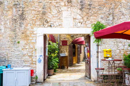 BUDVA, MONTENEGRO - JULY 12, 2014: The old gate to the town-citadel with the tiny street cafes, on July 12 in Budva.のeditorial素材
