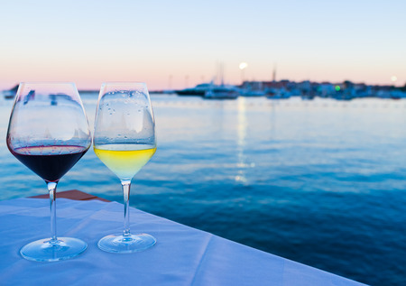 Glasses of wine with the view on the old town and port, Budva.の写真素材