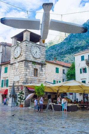 KOTOR, MONTENEGRO - JULY 12, 2014: The wooden figure of the seagull suspended above the Main Square with the Kampana tower on the background, on July 12 in Kotor.のeditorial素材