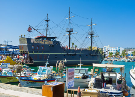 AYIA NAPA, CYPRUS - JULY 31, 2014: The port of the resort with the small fishing boats and wooden galleon Black Pearl for tourist trips along the coastline, on July 31 in Ayia Napa.のeditorial素材