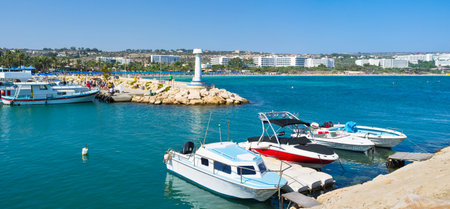 The port and coastline of Ayia Napa resort with many modern hotels, cozy beaches, amusement park and numerous boats for the tourist trips, Cyprus.のeditorial素材