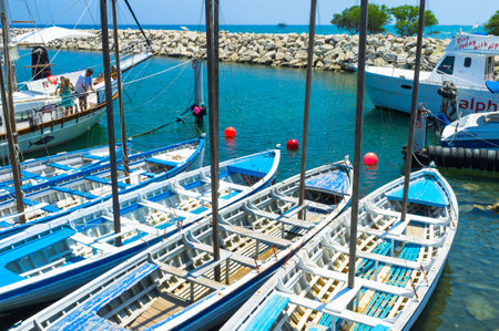 LARNAKA, CYPRUS - AUGUST 5, 2014: The old wooden boats are moored next to the large luxury yachts in...