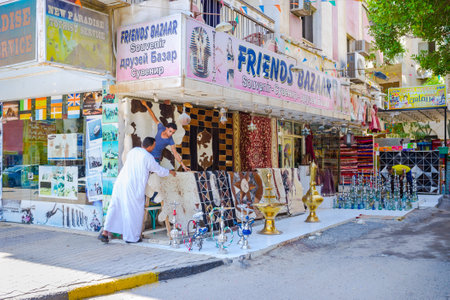 HURGHADA, EGYPT - OCTOBER 5, 2014: The sellers lay out the carpets and hookahs next to the large...