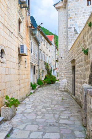 The narrow winding streetwith white stone houses, located at the foot of the mountain, Perast, Montenegro.のeditorial素材