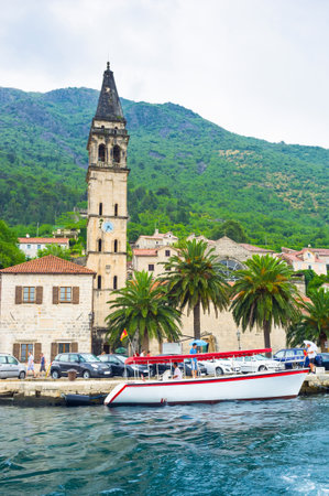 The bell tower of St Nicholas church and the main promenade during the rain, Perast, Montenegro.のeditorial素材